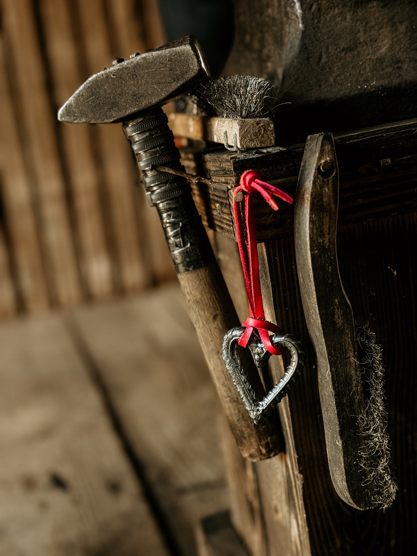 Vintage blacksmith tools with a heart-shaped ornament on a wooden background